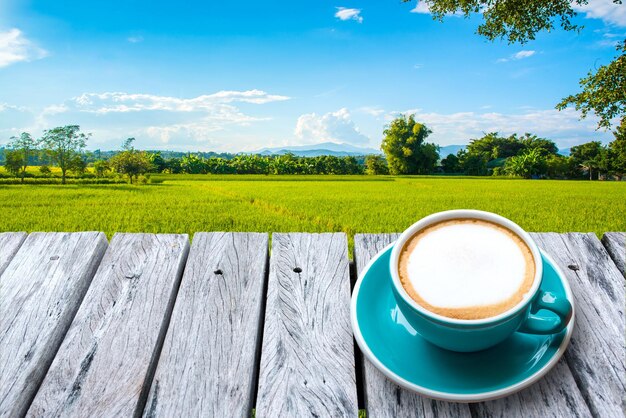 Foto una tazza di caffè sul tavolo vicino agli alberi contro il cielo