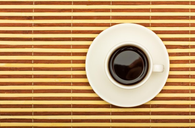 Foto vista superiore della tazza di caffè su un tavolo di bambù