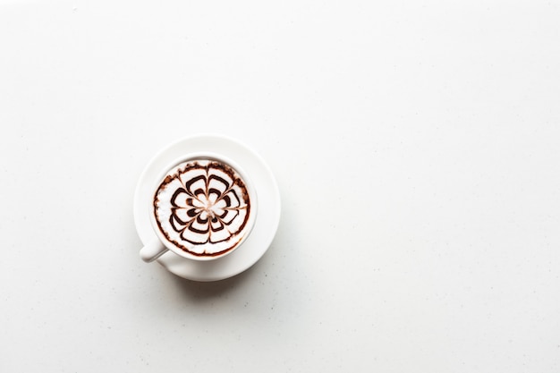 白いテーブルの上のコーヒーカップの上面図。コピースペース