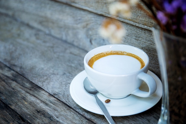 Tazza di caffè e vaso sul tavolo.