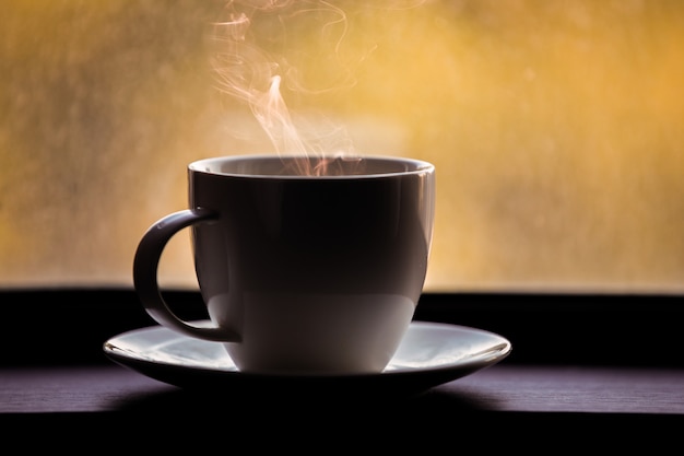 Foto tazza di caffè sul davanzale della finestra. sullo sfondo autunnale