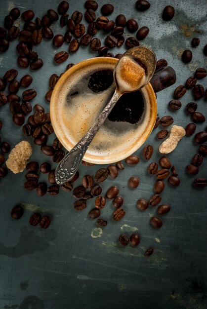 Coffee cup with beans and sugar on vintage metal, copy space, top view