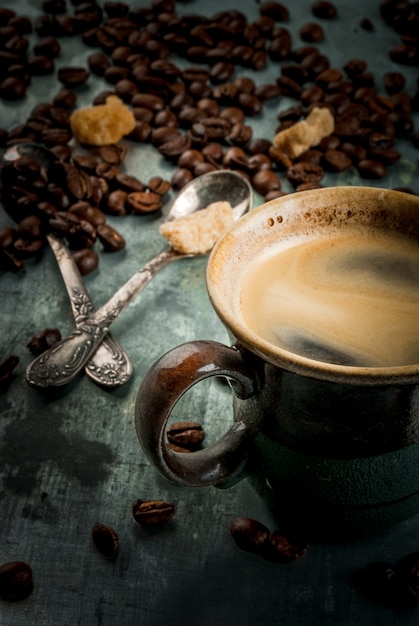 Coffee cup with beans and sugar on vintage metal, copy space