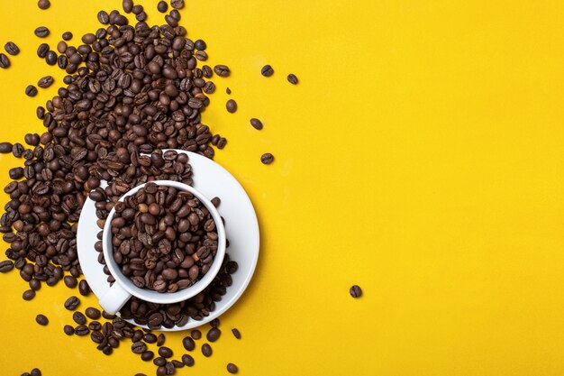 Coffee cup with beans on yellow