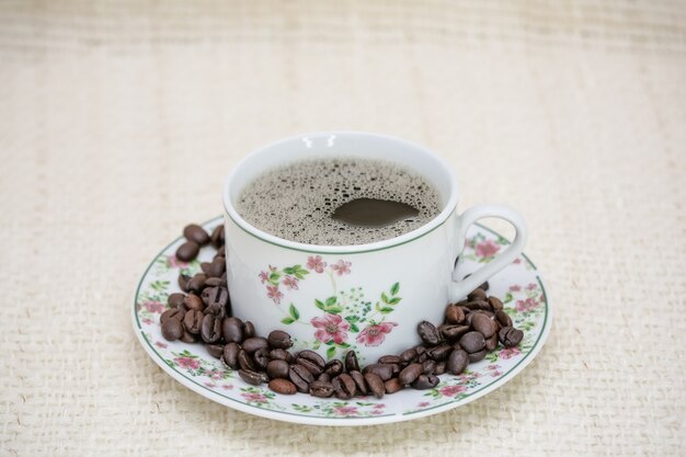 coffee cup with cheese bread and coffee beans on the side