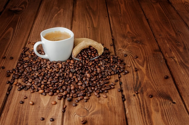 Coffee cup with coffee bag on wooden table. View from top