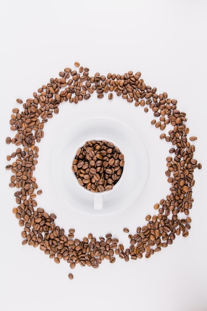 Foto tazza di caffè con chicchi di caffè su sfondo bianco