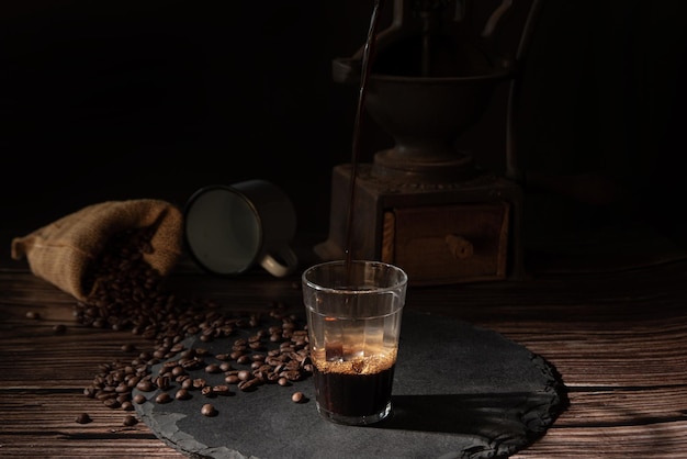 Coffee cup with coffee and coffee beans on a gray stone over wood dark food style photo selective focus