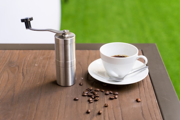 テーブルの上のコーヒーグラインダーとコーヒーカップ