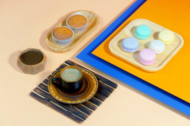 Coffee in a cup with dessert on a bright colored background