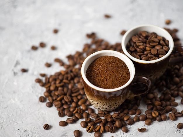 Tazza di caffè con caffè appena macinato e chicchi di caffè naturali