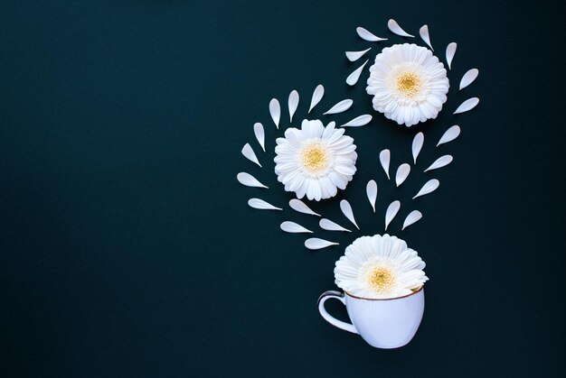 Foto tazza da caffè con petali di fiori di gerbera piatta