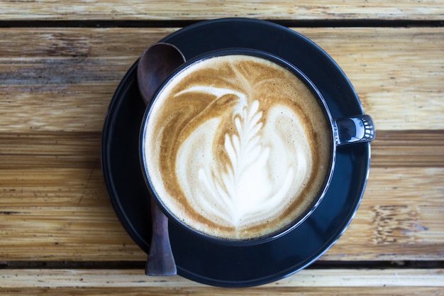 Coffee cup with morning sunlight on wood table background