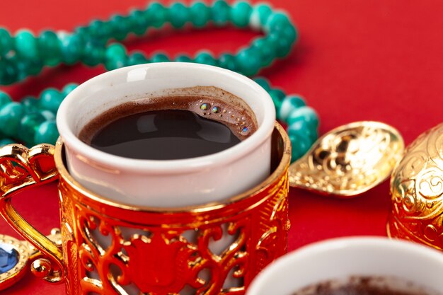 Coffee cup with praying beads on red background