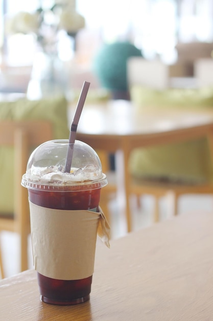 a coffee cup with a straw in it sits on a table