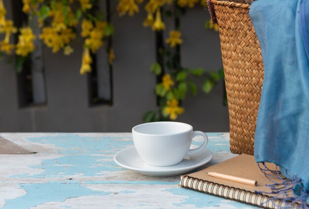 Photo coffee cup on wood table with brown memo notebook