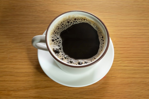 Coffee cup on wood texture background.