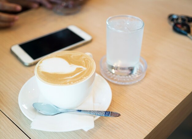 茶色の背景に木製のテーブルにコーヒーカップ