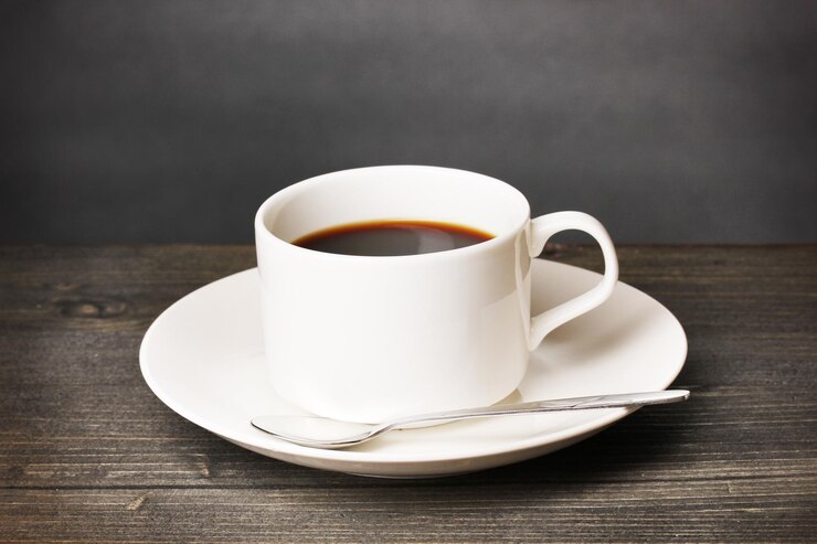 Photo 灰色の背景の木製のテーブル上のコーヒーカップ