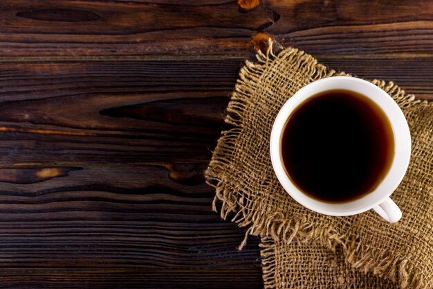 Coffee cup on wooden table texture. View from above