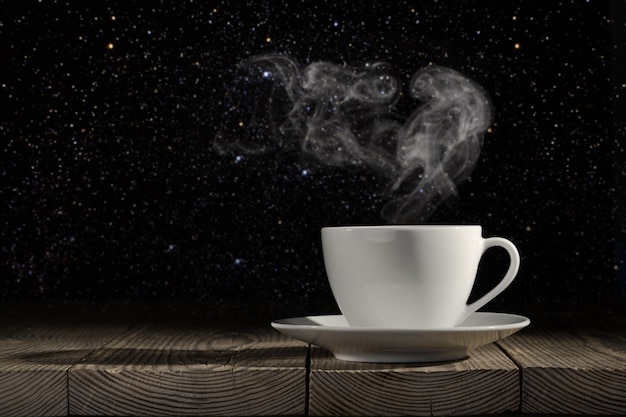 Coffee cup on wooden table with dark background