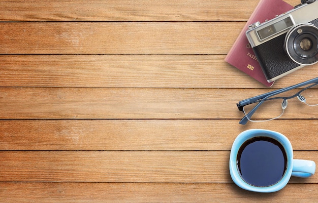 Coffee cupcamera and glasses on wooden table