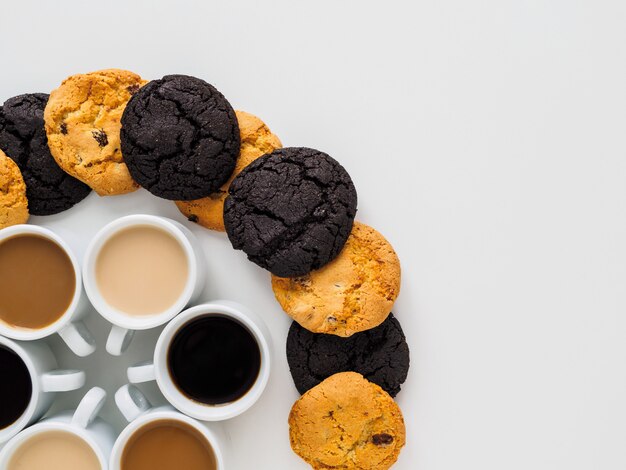 Coffee cups placed in a circle and different cookies