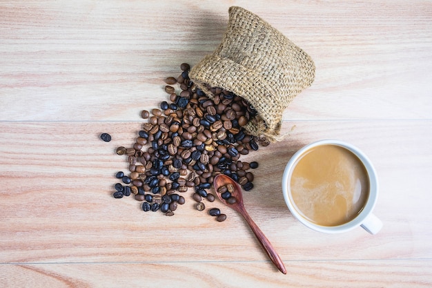 Coffee cups and roasted coffee beans on a wooden table