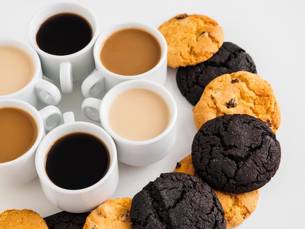 Coffee cups set in a circle and lots of sweets.