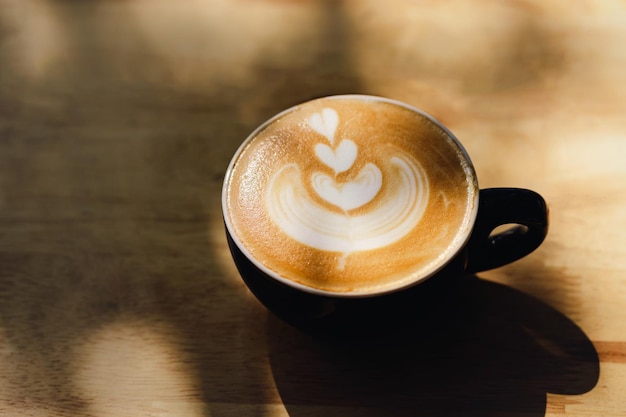 Coffee cups with latte art on wood background