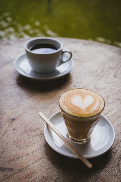 カフェの木製のテーブルの上のコーヒーカップ。