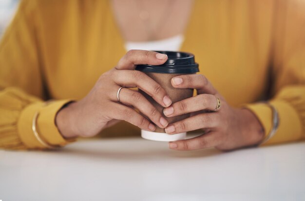 一日のコーヒーはブルースを遠ざけます認識できない実業家が彼女のオフィスに一人で座って一杯のコーヒーを持っているという切り取られたショット