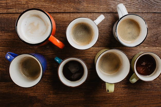 coffee in different cups on a wooden background