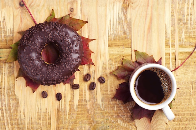 Coffee, donut and autumn leaves