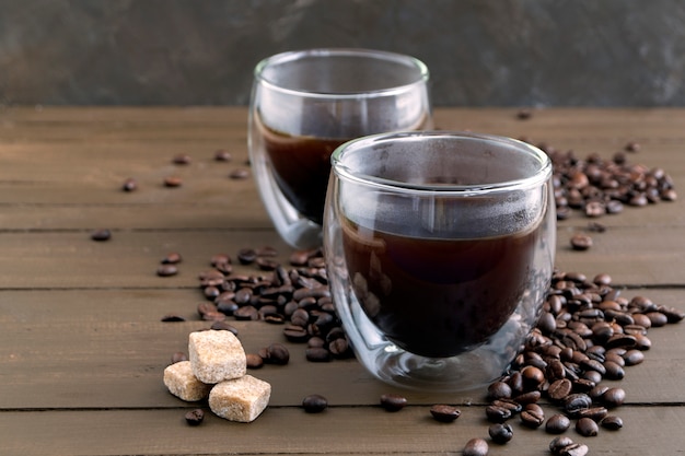 Coffee in double-walled glass on a wooden table.