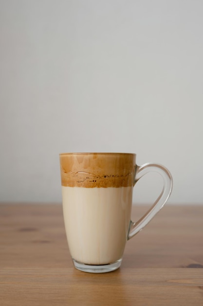 Coffee drink in a glass on a wooden table on a white background