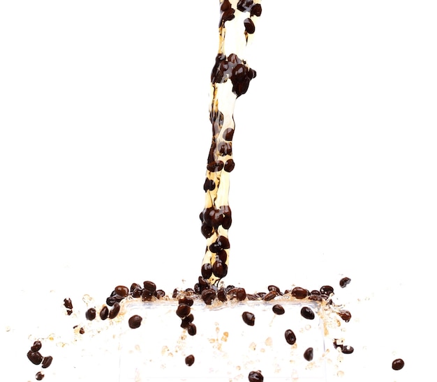 Кофейный напиток смешивается с водой, семена бобов падают вниз, образуя линию черного кофе с эспрессо.