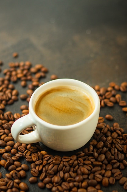 coffee drink in white cup and sprinkle coffee beans on the table