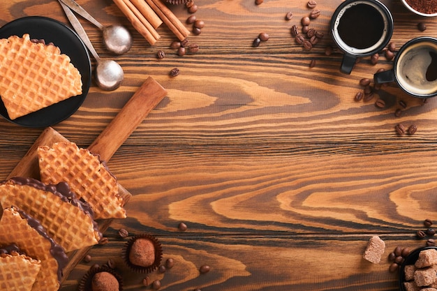 Coffee and dutch waffles Espresso coffee and dutch waffles or syrupwaffles cookies with chocolate on old wooden table Perfect syrupwaffles cookies for Breakfast Top view Mock up