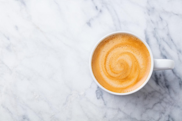 Coffee espresso in white cup of marble table background Top view Copy space