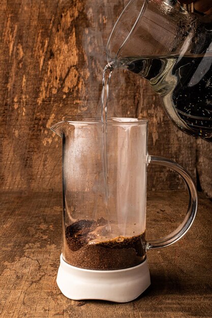 Coffee in french press with wooden background