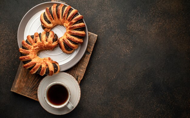 Caffè e pasticcini freschi, ciambelle con marmellata su uno sfondo di pietra con copia spazio per il testo