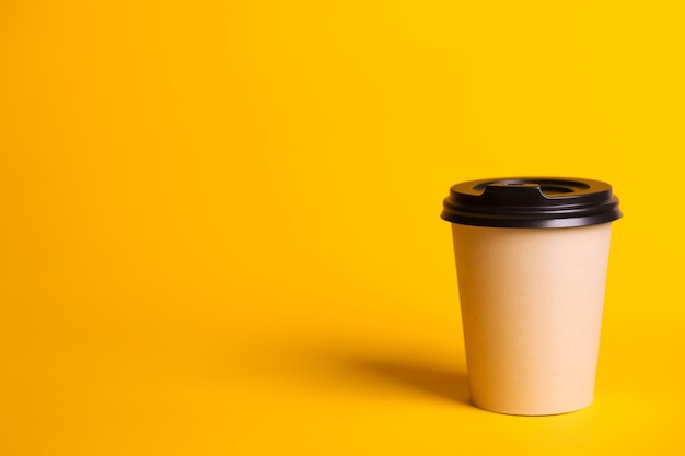 coffee to go paper cup with coffee on a yellow background