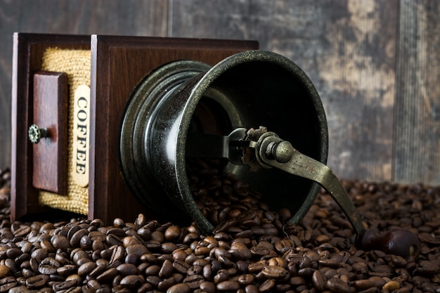 Coffee grinder and coffee beans on rustic wooden background