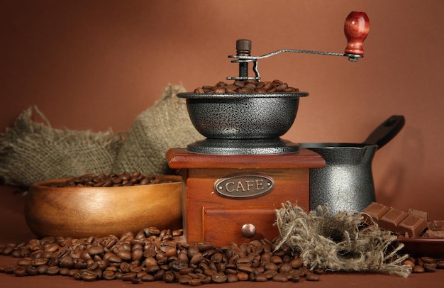 Coffee grinder turk and coffee beans on brown background