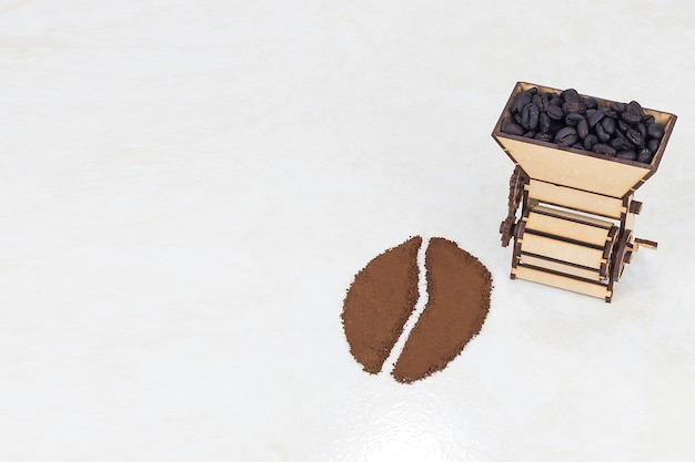 白で分離されたコーヒーから作られたコーヒー豆とコーヒー粉砕機のコンセプト