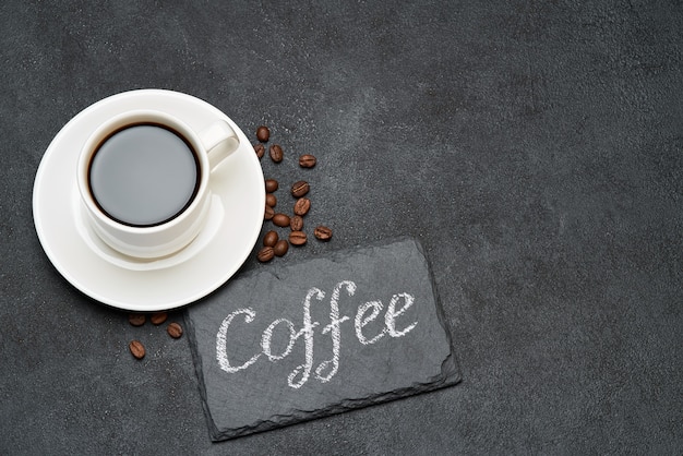 Coffee handwritten inscription sign on chalk board and cup of espresso coffee