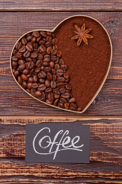 Coffee heart of beans and instant coffee with anise. Brown wooden table surface.