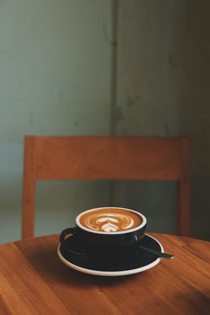 Coffee latte art in coffee shop in vintage color tone