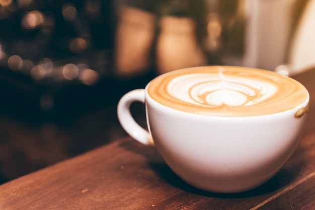 Foto arte del latte del caffè sulla tavola di legno in caffetteria